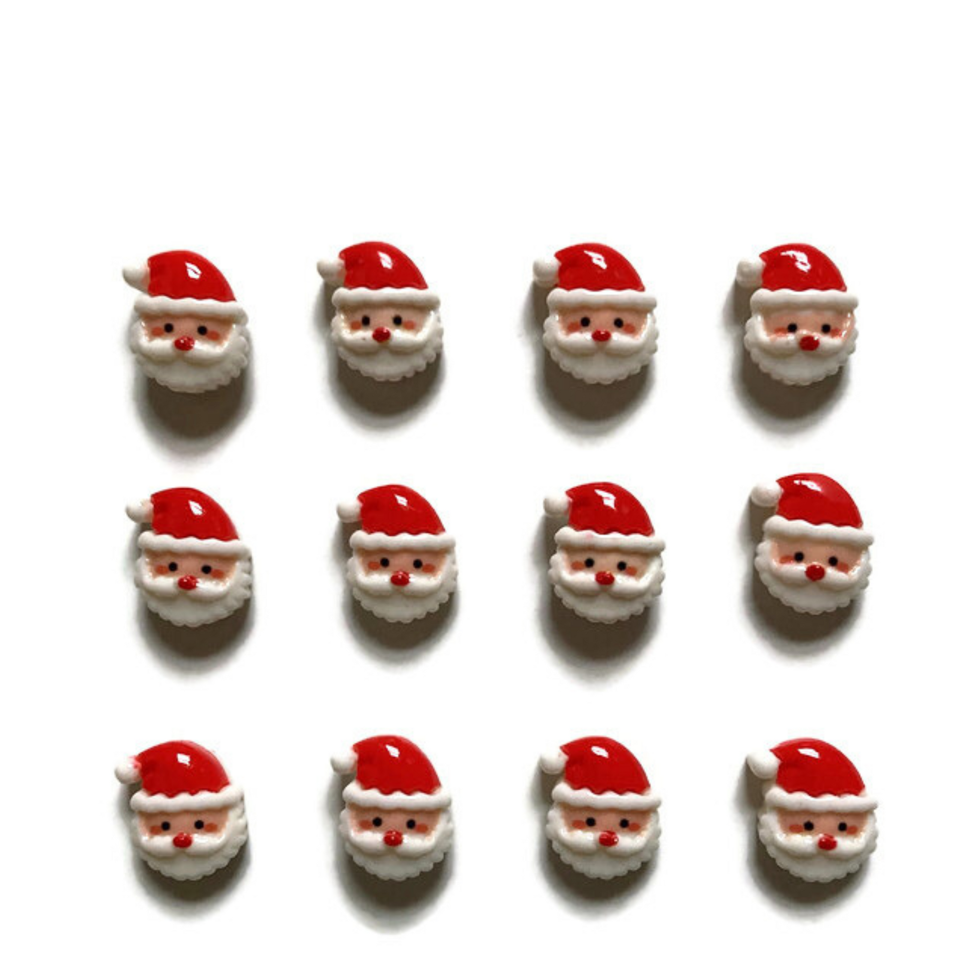 Twelve mini Santa face magnets on white background