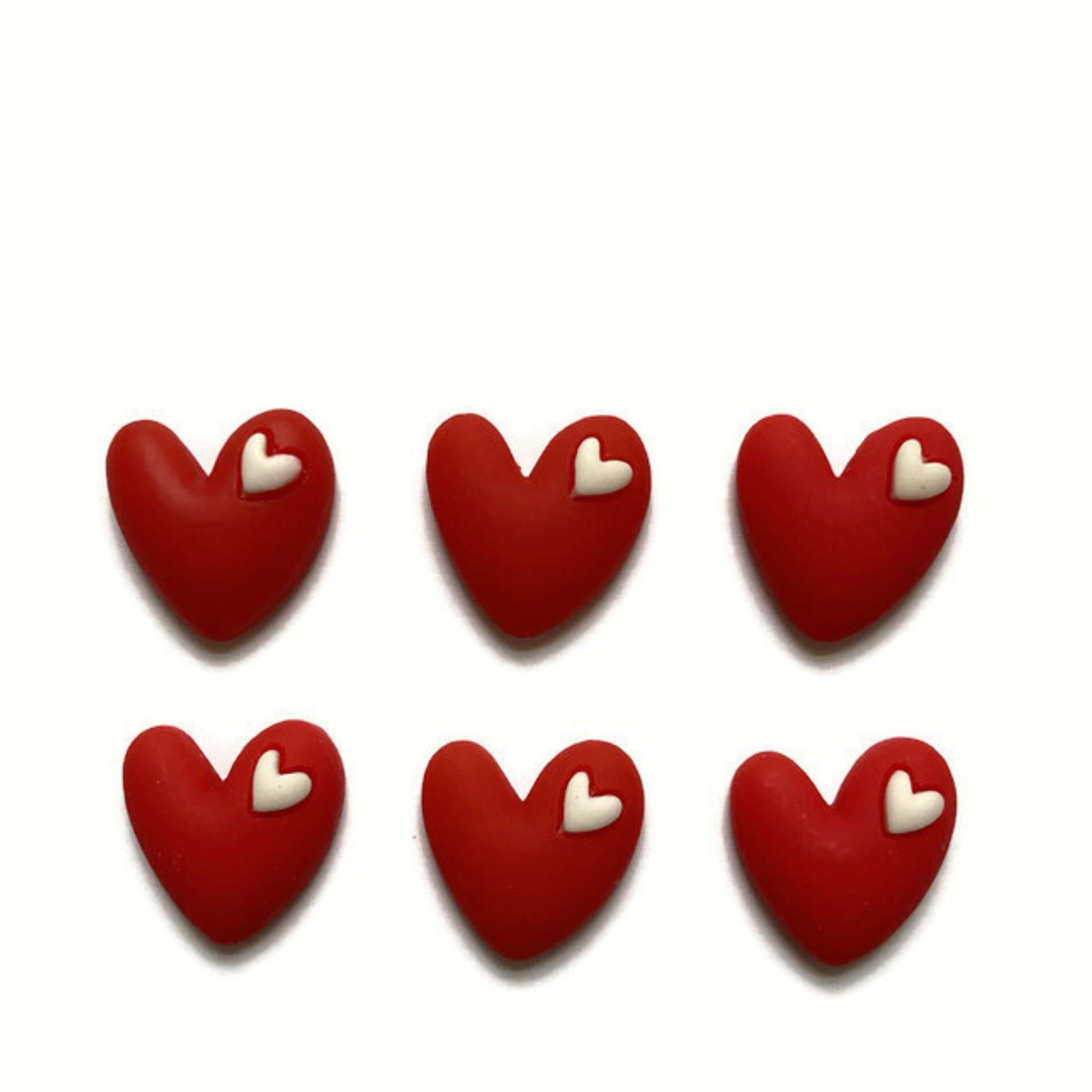 Six red heart magnets with small white heart in upper right corner of each magnet. Magnets are on a white background.