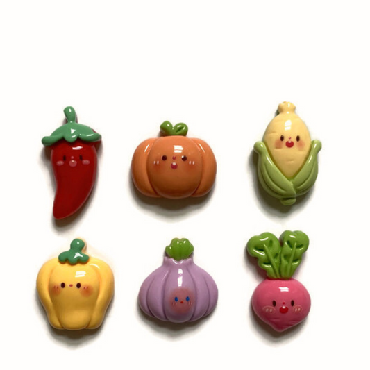 Six vegetable magnets on white background including red chili pepper, orange pumpkin, yellow corn, yellow pepper, purple onion, and pink radish